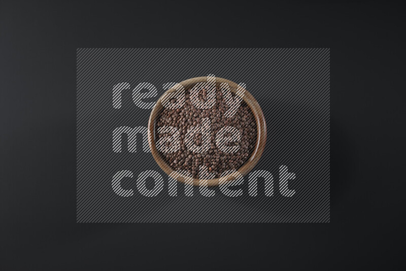 Brown lentils in a wooden bowl on grey background