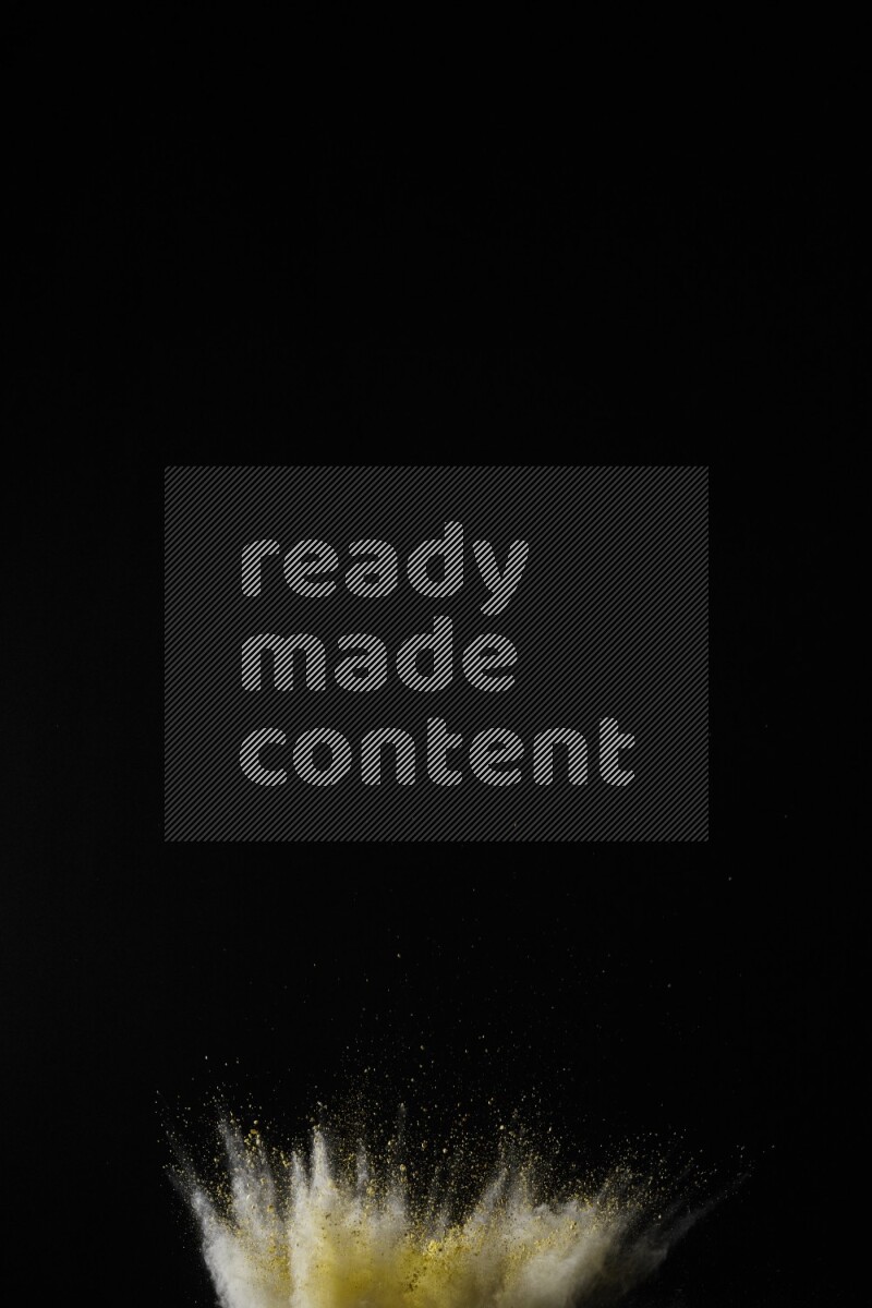 A side view of yellow powder explosion on black background