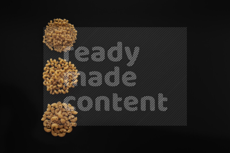 Different pasta types in 3 bunches on black background