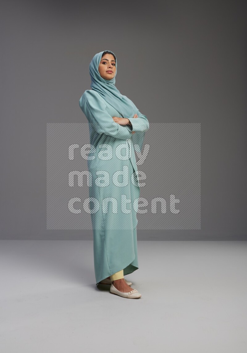 Saudi Woman wearing Abaya standing with crossed arms on Gray background