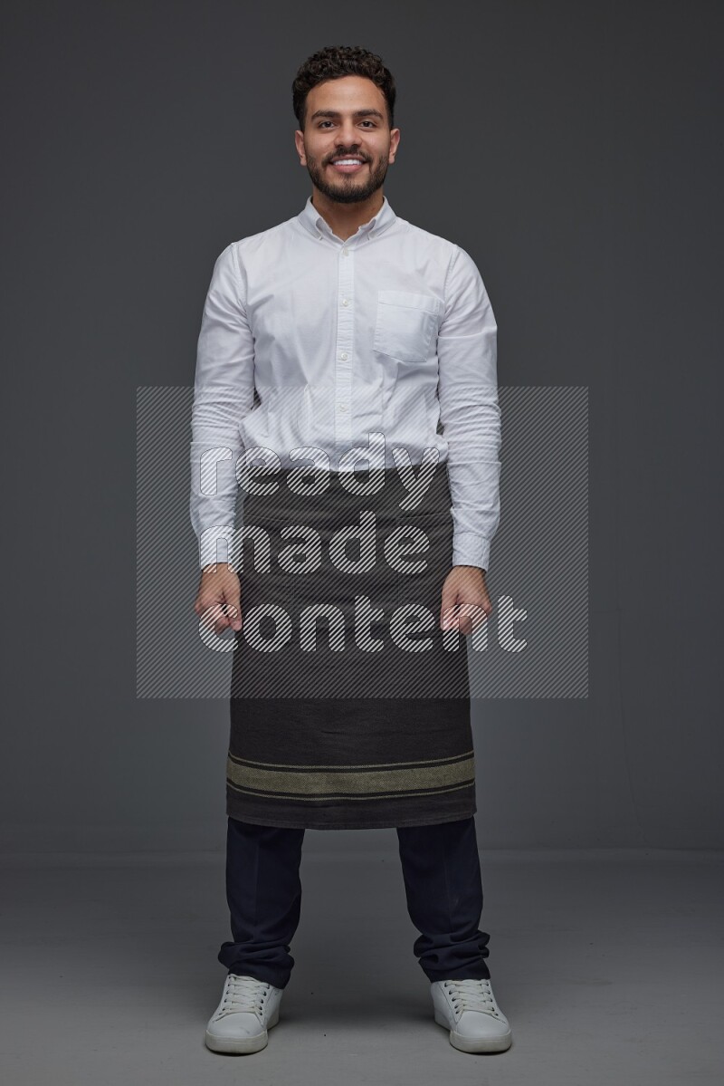 A man wearing smart casual and apron standing and making multi poses eye level on a gray background