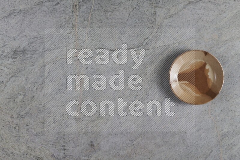 A multicolored pottery plate on grey marble background
