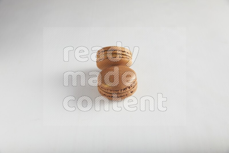 45º Shot of of two assorted Brown Irish Cream, and Brown Coffee macarons  on white background