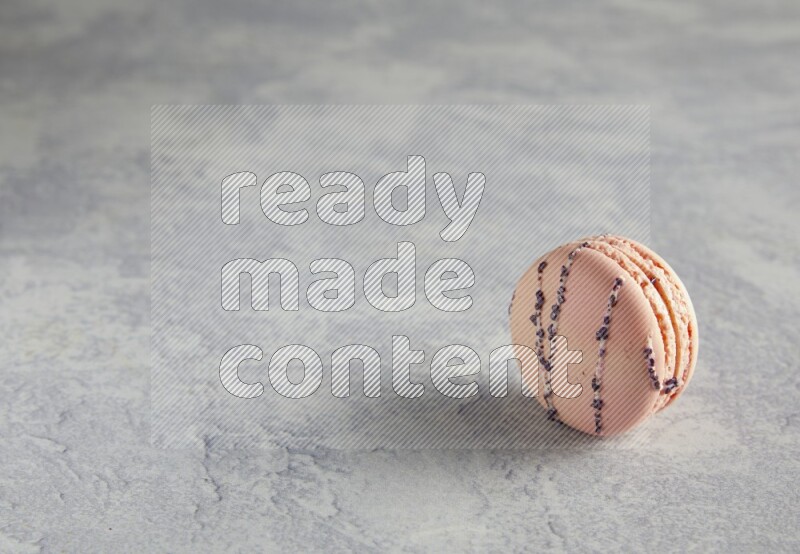 45º Shot of pink orange blossom macaron on white  marble background