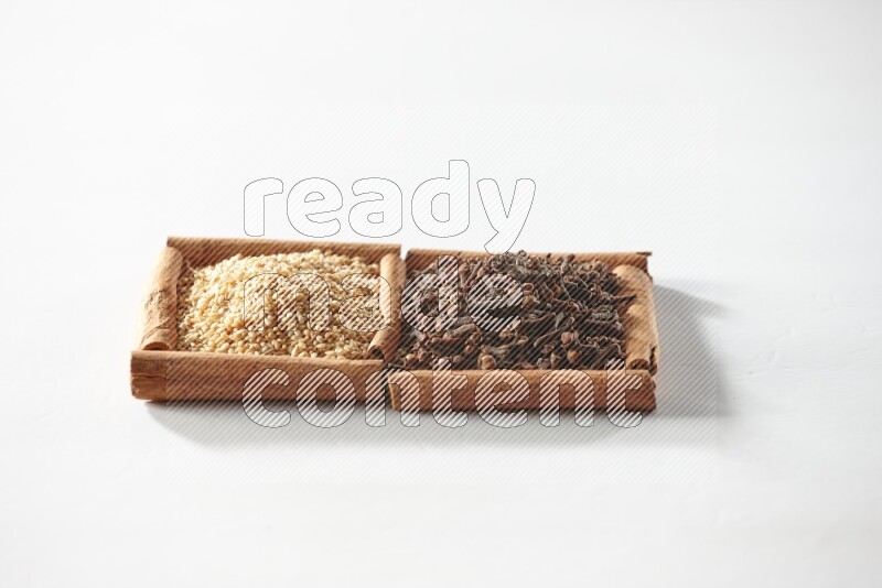 2 squares of cinnamon sticks full of cloves and sesame on white flooring