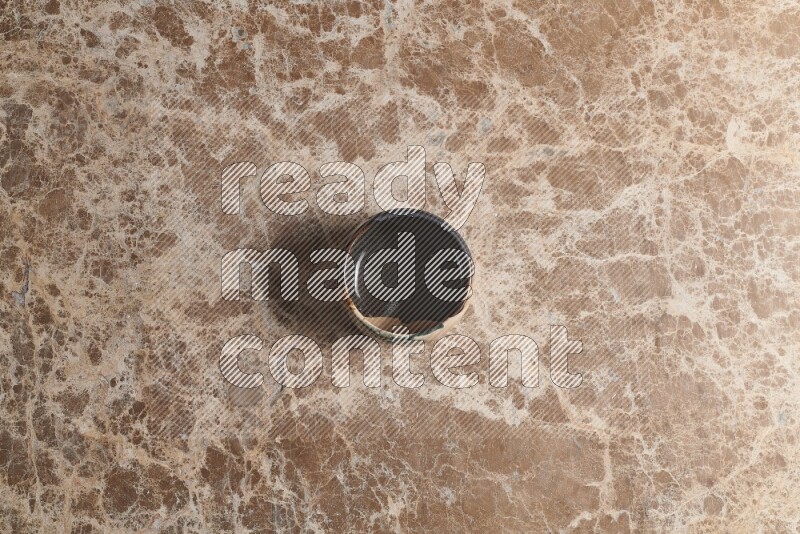 A multicolored pottery bowl on beige marble background