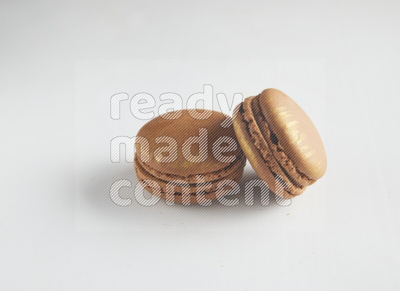 45º Shot of two Brown Coffee macarons on white background