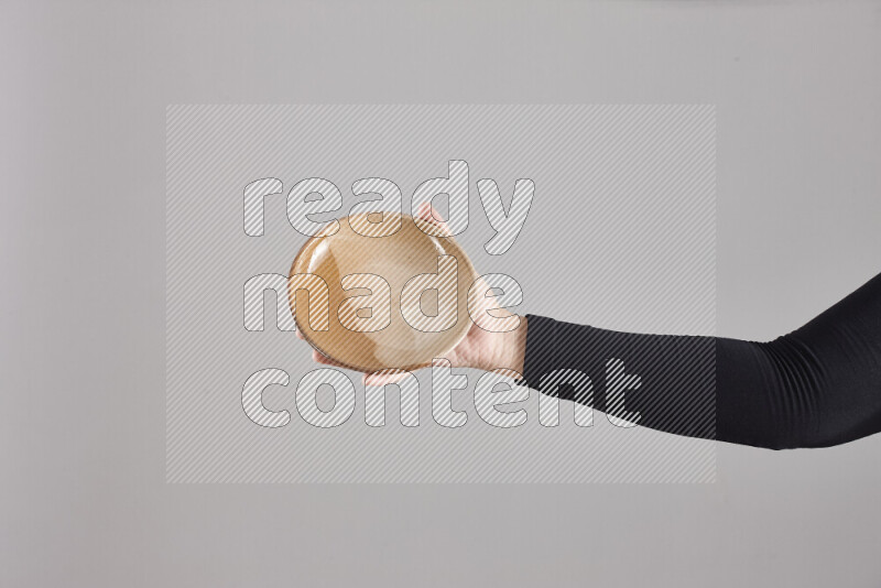 A woman in black abaya holding different pottery essentials in different positions