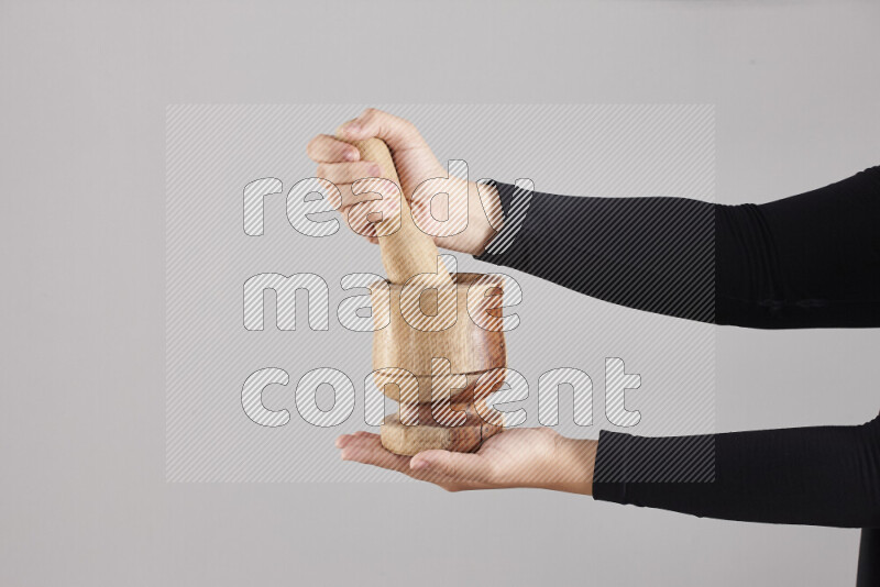 A woman in black abaya holding different wooden essentials in different positions