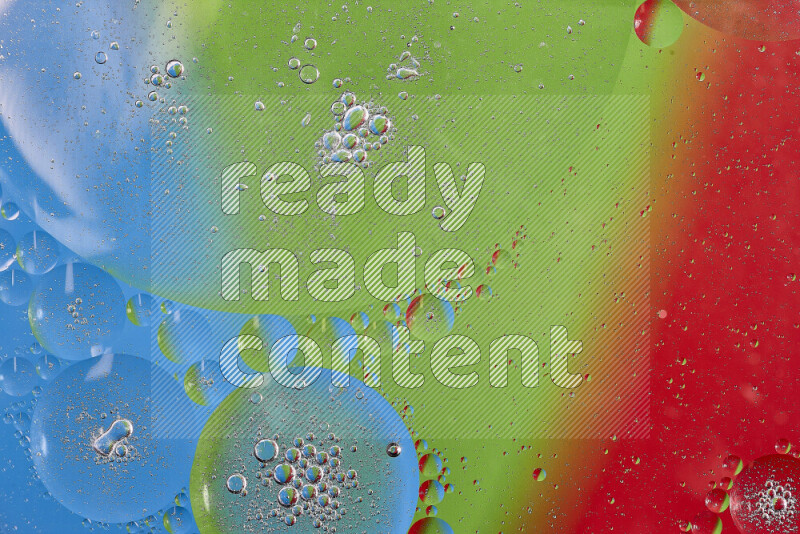 Close-ups of abstract oil bubbles on water surface in shades of red, green and blue