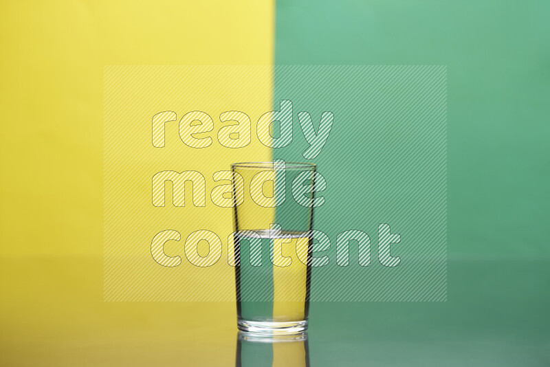 The image features a clear glassware filled with water, set against yellow and green background