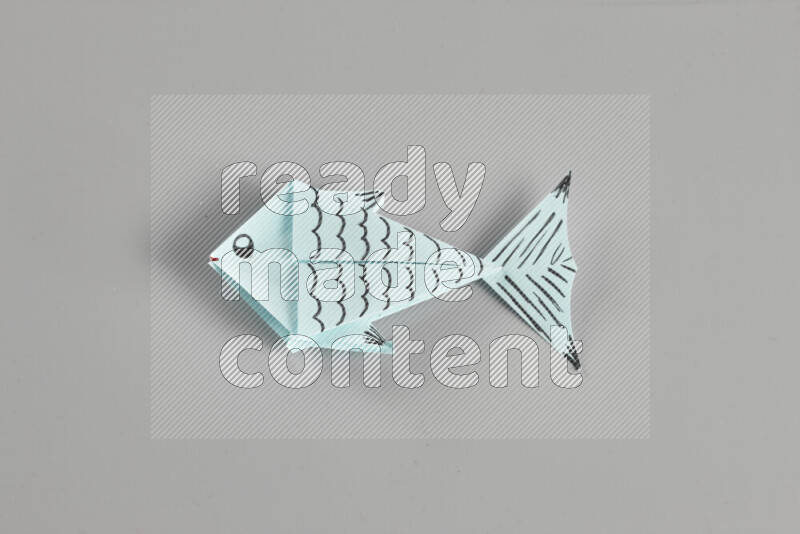 Origami fish on grey background