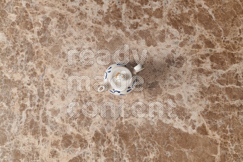 A pottery teapot on beige marble background