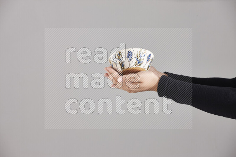 A woman in black abaya holding different pottery essentials in different positions