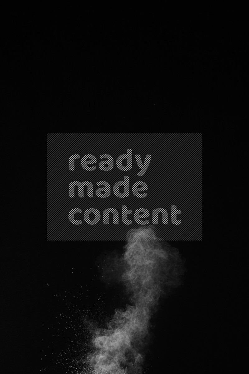 A side view of white powder explosion on black background