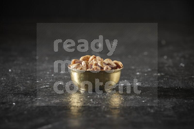 Nuts in a metal bowl in a dark setup