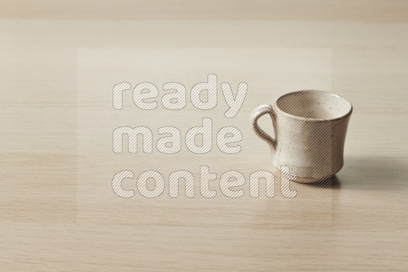 A pottery cup on light wooden background