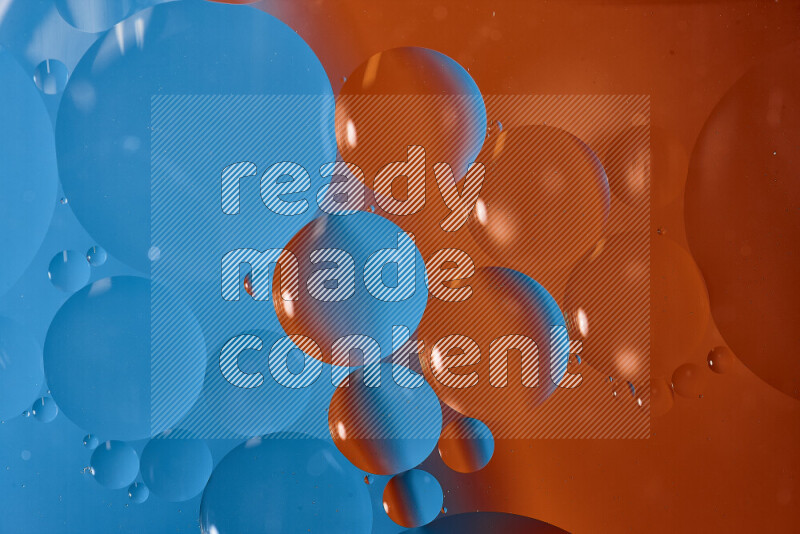 لقطات مقربة لفقاعات من الزيت على سطح الماء باللون الأزرق والبرتقالي