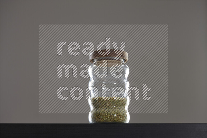 Freekeh in a glass jar on black background