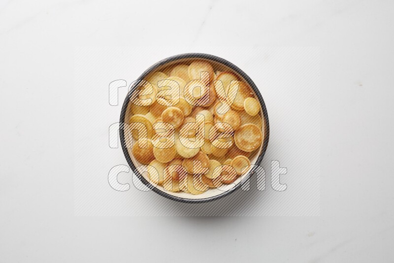 Top-view shot of plain cereal pancakes in a round bowl on white background