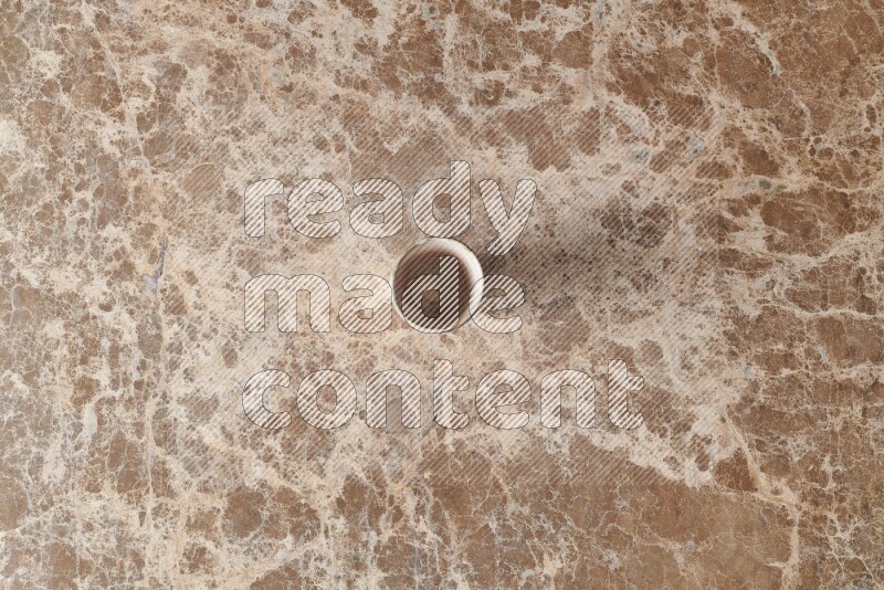 A pottery cup on beige marble background