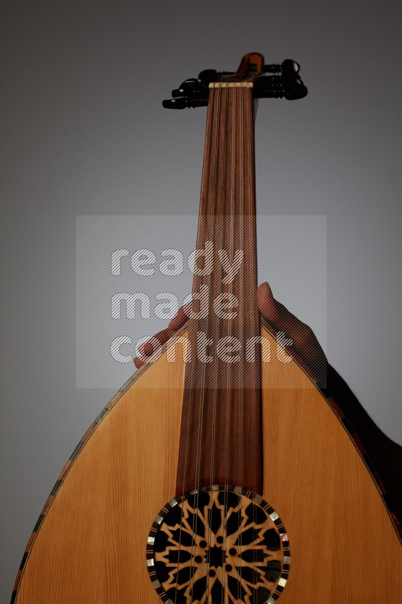 a hand intracting with a wooden brown Oud