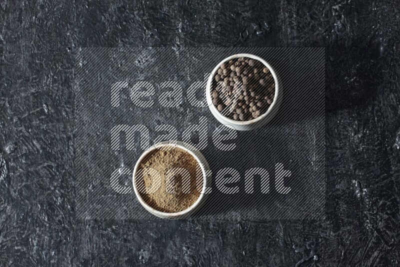 وعاءان بيج، أحدهما ممتلئ ببودرة بهار الفلفل الحلو والآخر بالحبوب على خلفية سوداء