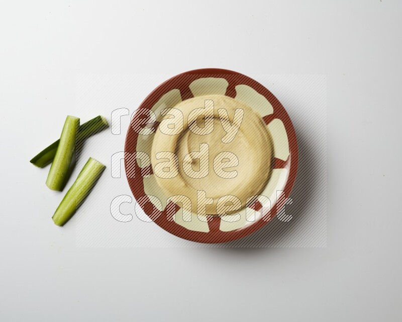 Plain hummus in a traditional plate on a white background