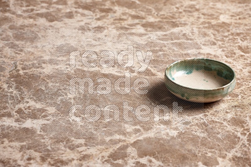 A multicolored pottery plate on beige marble background