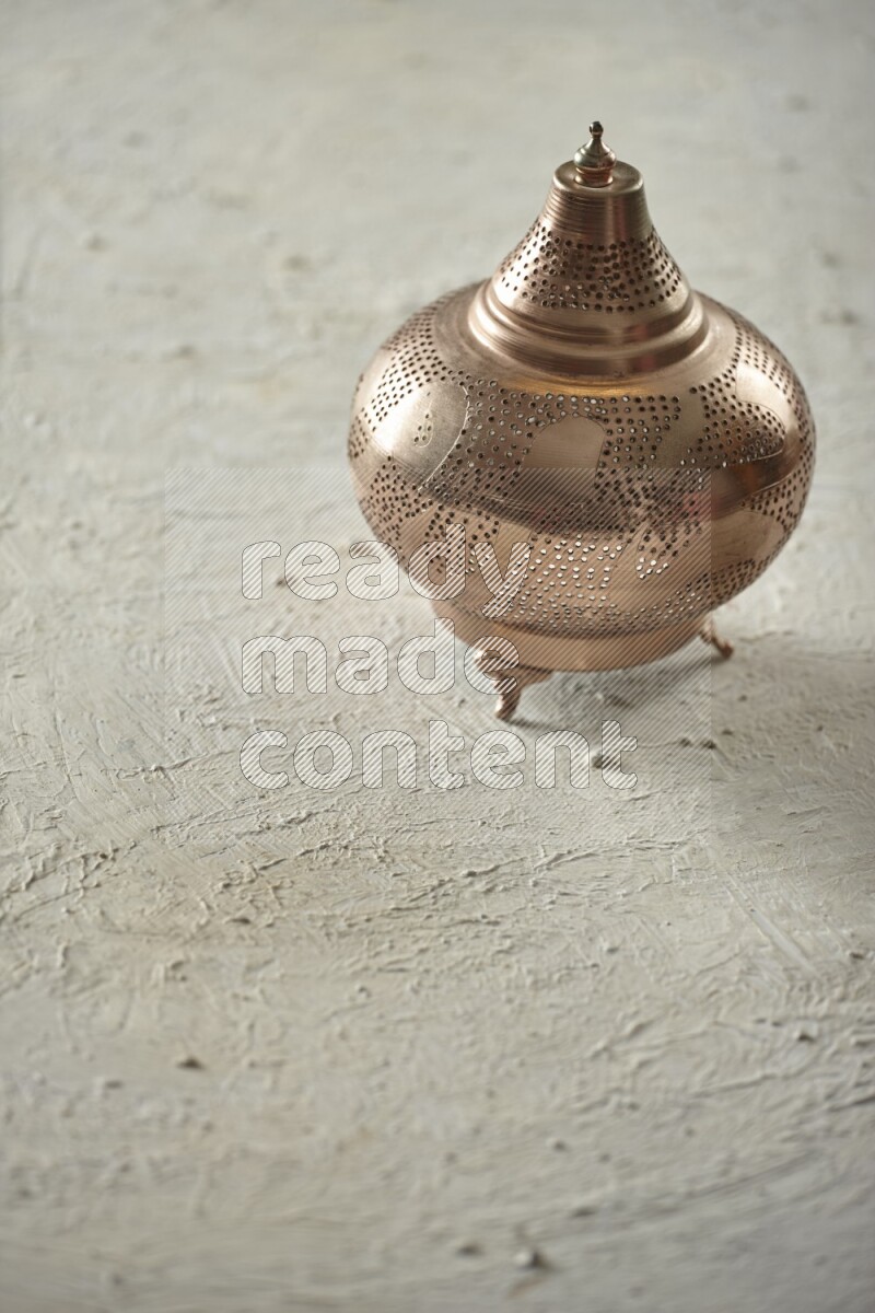 A lantern placed on a textured white background