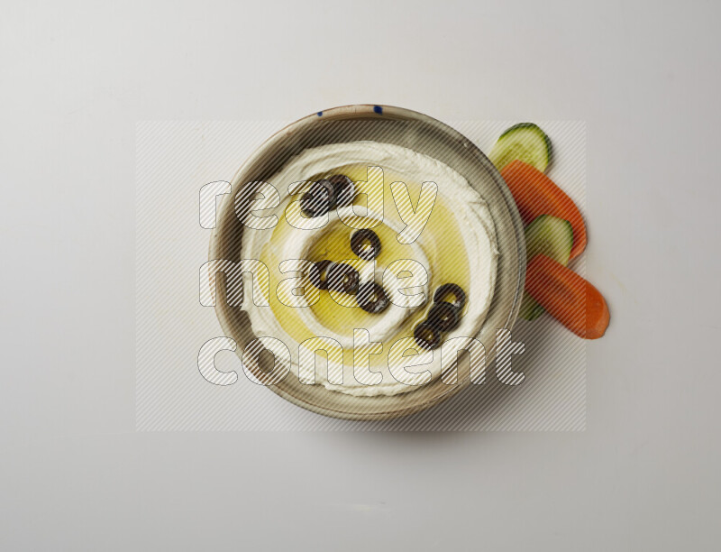 Lebnah garnished with sliced olives in a grey pottery plate on a white background