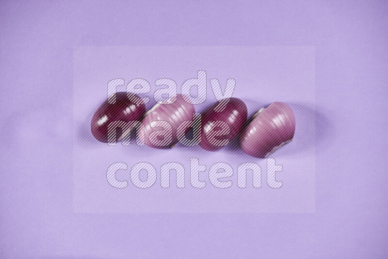 Halves red onions on a purple background