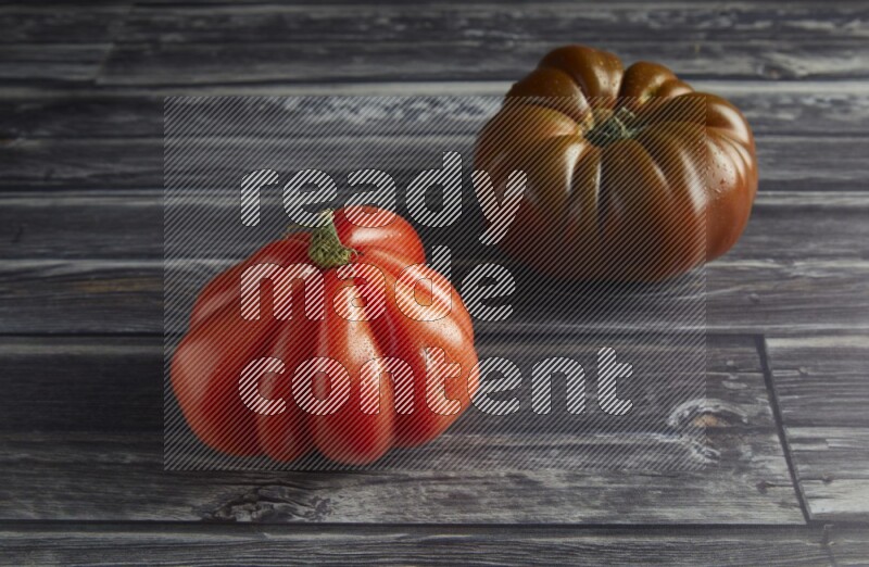 45 degree two heirloom tomato on a textured grey wooden background