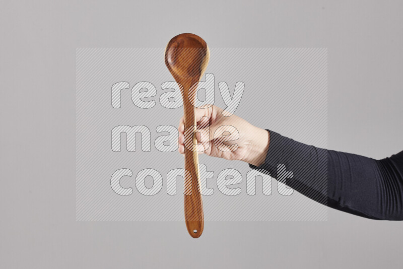 A woman in black abaya holding different wooden essentials in different positions