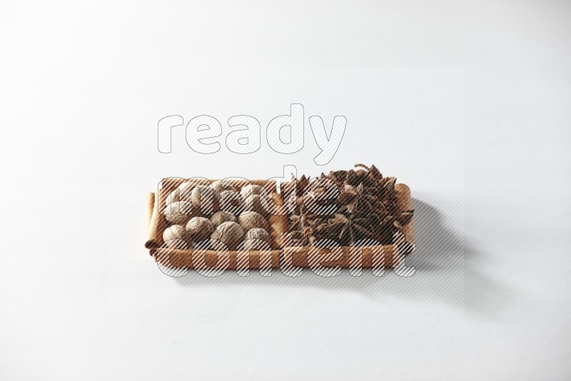 مربعان من أعواد القرفة ممتلئان باليانسون النجمي وجوزة الطيب علي خلفية بيضاء