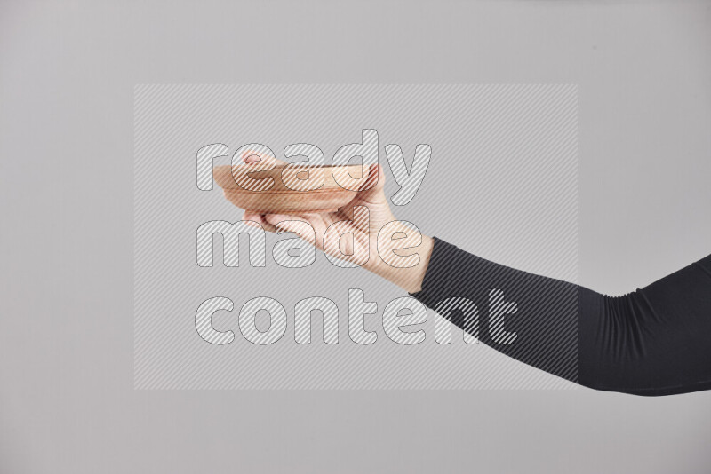 امرأة ترتدي عباءة سوداء تحمل أدوات خشبية مختلفة في أوضاع متعددة