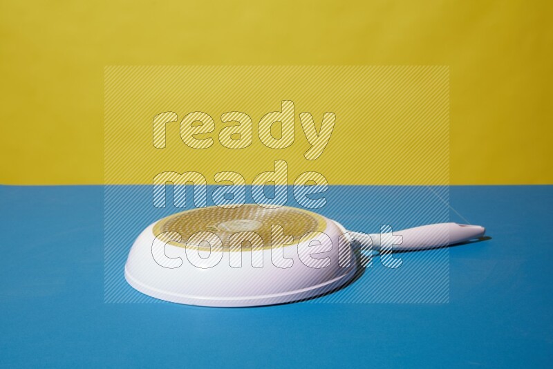 white pan on yellow and Blue background