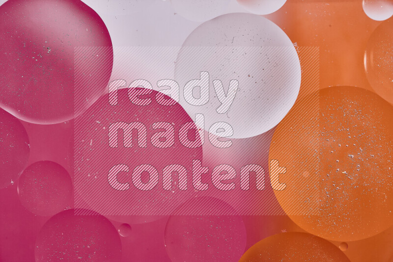 Close-ups of abstract oil bubbles on water surface in shades of white, orange and pink