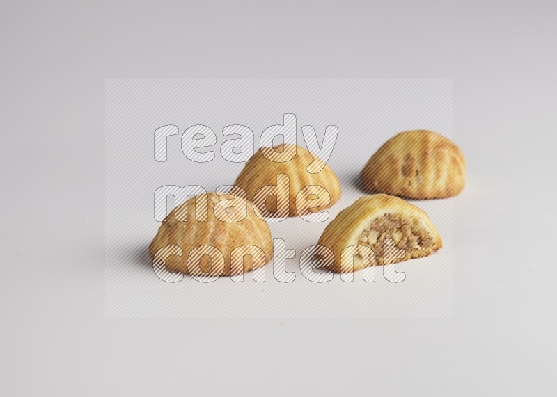 Four Pieces of Maamoul filled with walnut paste  one of them is cut direct on white background