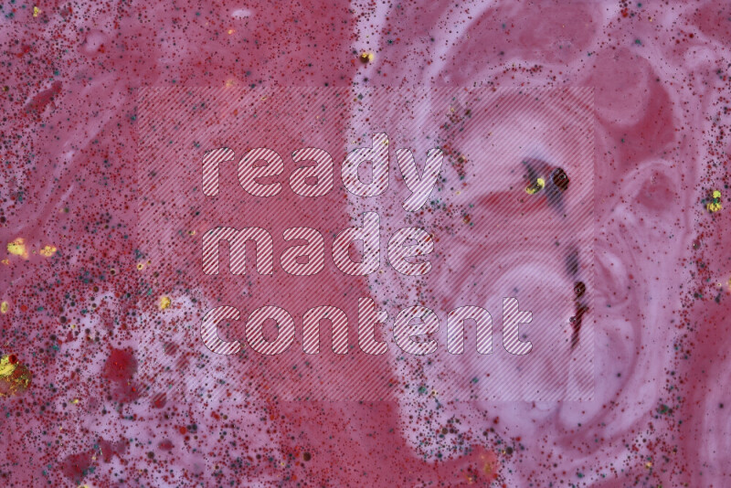 A close-up of abstract swirling patterns in red with colored particles