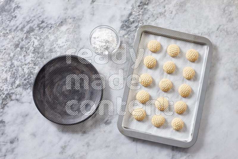 Kahk step by step with its ingredients ghee, sugar, flour, sesame, yeast, water and kahk flavor on grey marble background