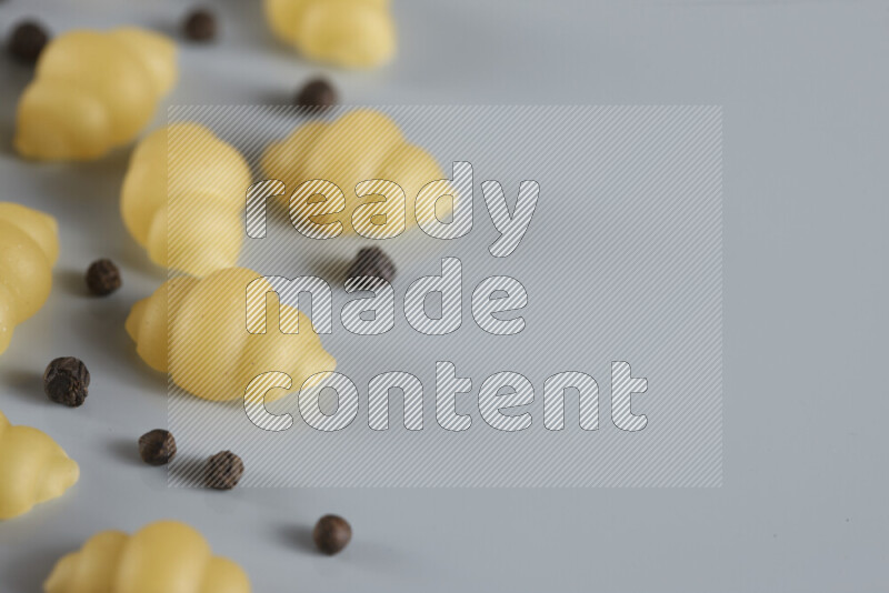 معكرونة مع مكونات متنوعة من الطماطم والثوم والبصل والفلفل الأحمر والفلفل الأسود والفلفل الأبيض وأوراق الغار وإكليل الجبل والهيل و مشروم على خلفية زرقاء فاتحة