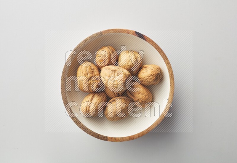 Top-view shot of walnut in a container on white background
