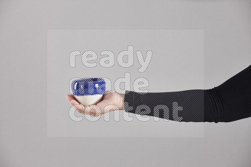 A woman in black abaya holding different pottery essentials in different positions