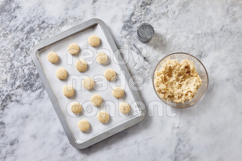 Kahk step by step with its ingredients ghee, sugar, flour, sesame, yeast, water and kahk flavor on grey marble background