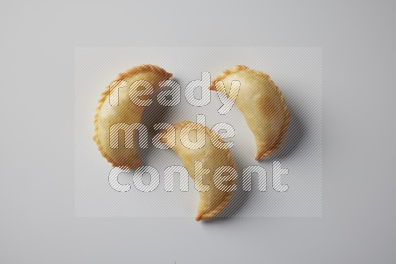 Three fried sambosa from a top angle on a white background