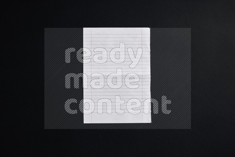Folded notebook sheet on black background