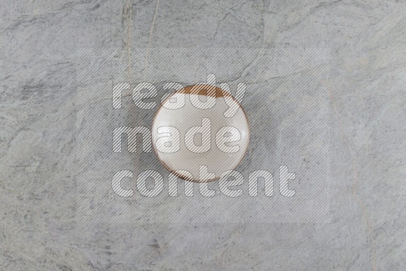A multicolored pottery plate on grey marble background