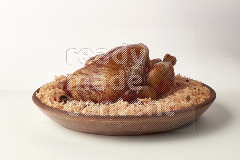 red basmati Rice with whole roasted chicken on a pottery plate direct on white background