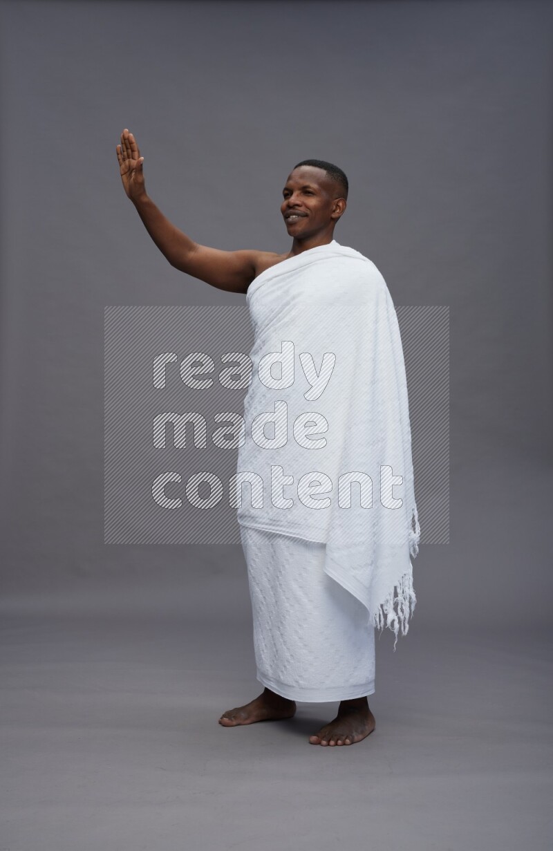 A man wearing Ehram Standing Interacting with the camera on gray background